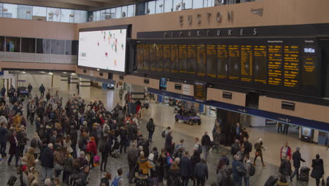 Plano-general-de-personas-que-abandonan-el-vestíbulo-de-la-estación-de-tren