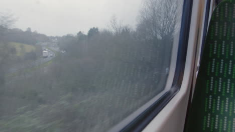 Looking-out-train-window-passing-road-with-traffic