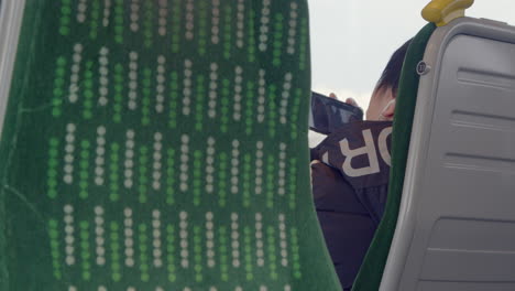 Passenger-watching-tv-on-teléfono-on-a-train