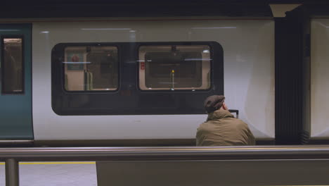 Hombre-sentado-en-un-banco-viendo-el-tren