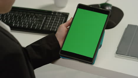 Cu-Frau-Am-Schreibtisch-Hält-Tablet-Mit-Grünem-Bildschirm