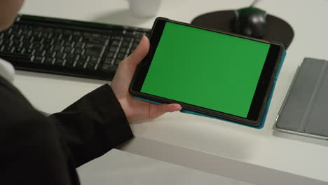 CU-Woman-at-Desk-Holding-Tablet-with-Green-Screen