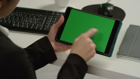 CU-Woman-at-Swipes-en-tableta-con-pantalla-verde