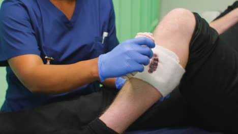 Cu-Krankenschwester-Bandagiert-Blutiges-Verletztes-Bein