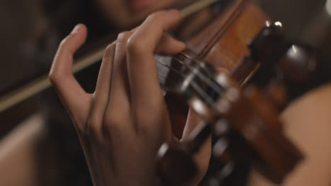 Close-Up-Violin-Scroll-And-Hand-Playing-Violin