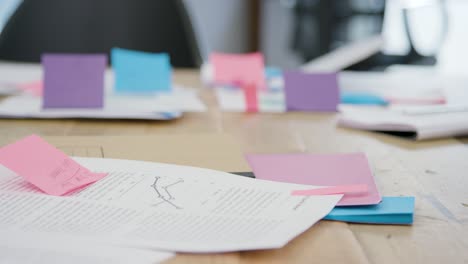 Pan-Of-Paperwork-And-Notes-On-Table-In-Office