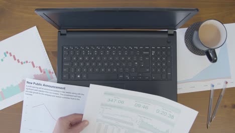 Overhead-Male-Looking-at-Business-Reports-Using-Laptop