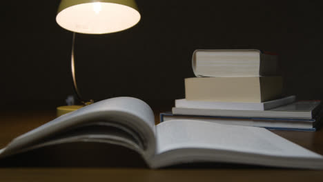 Pull-Focus-Open-Book-to-Stack-of-Books-on-Table