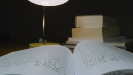 Tracking-Out-Close-Up-of-Open-Book-on-Table