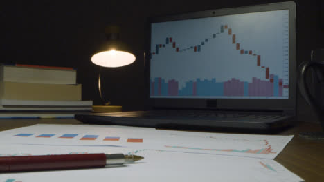 Börsencharts-Auf-Laptop-Und-Schreibtisch-In-Der-Nacht