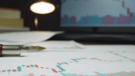 Close-Up-Stock-Market-Graphs-on-Desk-at-Night