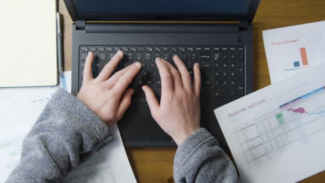 Overhead-Mann-Im-Morgenmantel-Tippt-Auf-Laptop