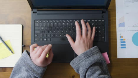 Overhead-Male-in-Robe-Types-on-Laptop