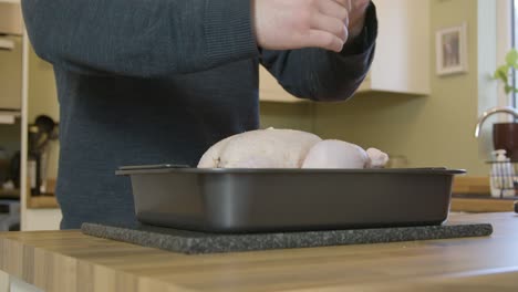 Man-Grinding-Pepper-onto-Uncooked-Chicken
