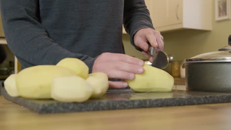 Tracking-Out-Man-Chopping-Potatoes-in-Kitchen