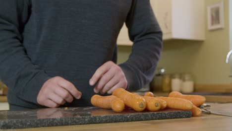 Mann-Beginnt-In-Der-Küche-Karotten-Zu-Schälen