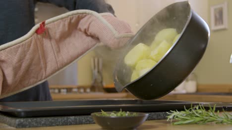 Male-Putting-Steaming-Potatoes-on-Oven-Tray