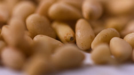 Extreme-Close-Up-Pine-Nuts-Falling-On-Flat-Surface