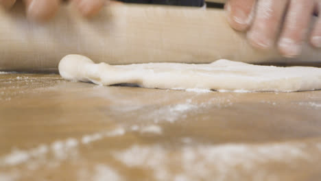 Male-Rolling-Dough-on-Kitchen-Worktop