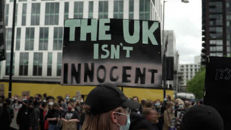 London-Protestor-Holds-Up-UK-Isn't-Innocent-Sign-BLM