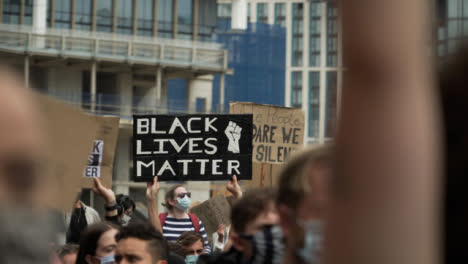 London-Protestor-Holds-Up-BLM-Sign-in-Chanting-Crowd