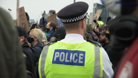 Londoner-Polizist-Beobachtet-Menge-Von-Demonstranten