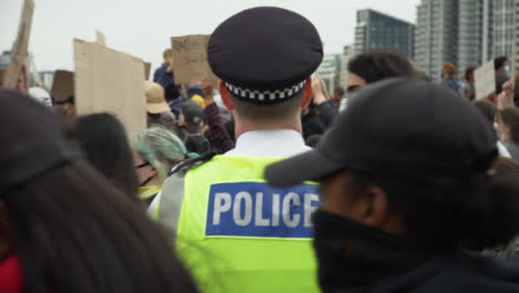 London-Protesters-Walk-Past-Police-Officer-During-March