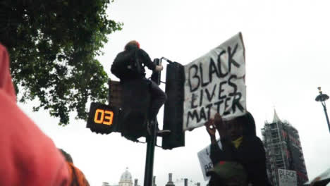 London-Protestor-Sits-On-Traffic-Light-During-Black-Lives-Matter-Demonstrations