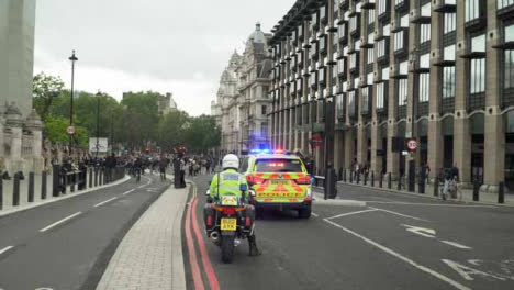 Londoner-Polizeimotorrad-Und-Auto-Vor-Der-Menge-Von-Demonstranten