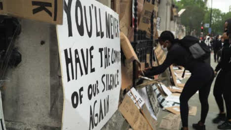 London-Protester-Adds-Sign-to-Railing-with-Black-Lives-Matter-Signs