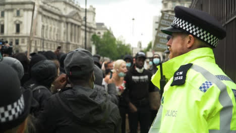 London-Policía-Officer-Standing-in-Front-of-Protesters