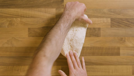 Top-View-Kneading-a-Sticky-Dough-on-Worktop