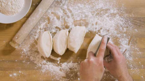 Top-View-Male-Cuts-Dough-Using-Dough-Scraper