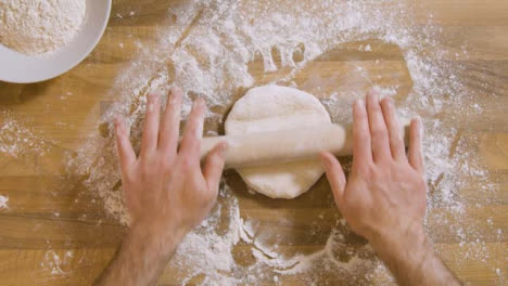 Top-View-Male-Uses-Rolling-Pin-on-Dough