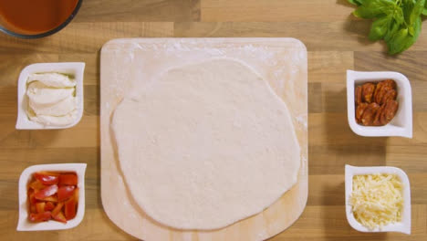 Top-View-Pizza-Dough-on-Peel-Placed-on-Worktop