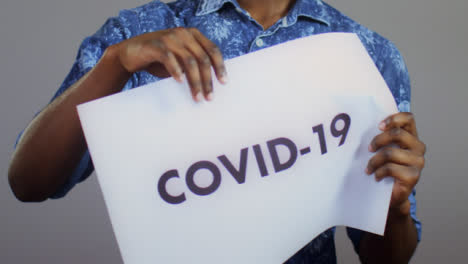 Close-Up-of-Man-Ripping-Covid-19-Sign