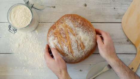 Top-View-Hands-Placing-Fresh-Bread-on-Table