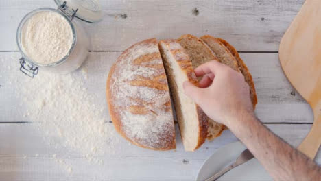 Top-View-Hand-Picking-Up-Slice-of-Fresh-Bread