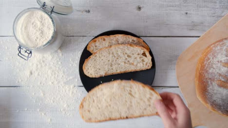 Hand-Von-Oben,-Die-Eine-Scheibe-Brot-Vom-Teller-Nimmt