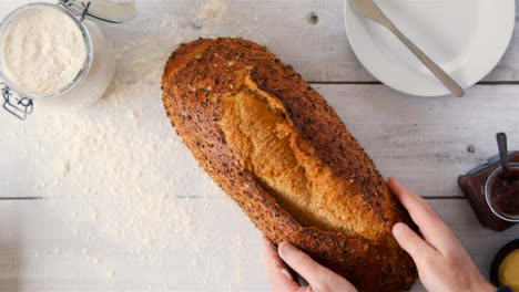 Top-View-Hands-Pick-Up-Seeded-Bread-on-Table