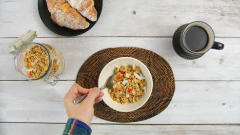 Top-View-Eating-Granola-from-Bowl-at-Breakfast