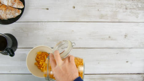 Draufsicht,-Die-Beim-Frühstück-Cornflakes-In-Eine-Schüssel-Gießt