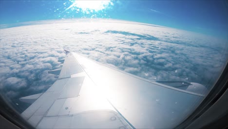 Avión-flight.-Wing-of-an-avión-flying-above-the-clouds-with-sunset-sky.-View-from-the-window-of-the-plane.-Avión,-Aircraft.-Traveling-by-air.-Optical-flares.