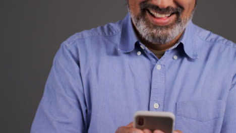 Mann-Mittleren-Alters,-Der-Auf-Seinem-Handy-Eine-SMS-Schreibt