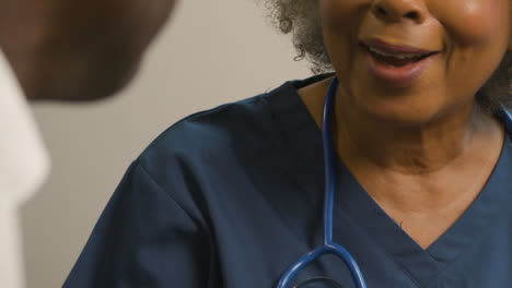 Close-Up-Smiling-Middle-Aged-Doctor-Talking-to-Patient