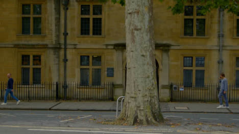 Wide-Shot-of-People-Walking-Past-Old-College-In-Oxford