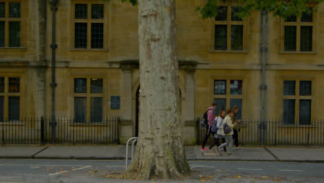 Wide-Shot-of-People-Walking-Past-Old-College-In-Oxford-England