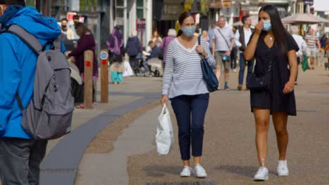 Two-Women-In-face-Masks-Walking-Down-Busy-Cornmarket-Street-In-Oxford