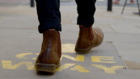 Tracking-Shot-of-Feet-Walking-Over-One-Way-Floor-Marking-In-Oxford-