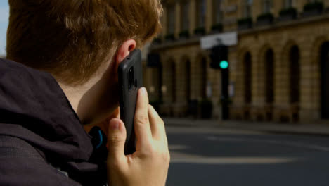 Over-the-Shoulder-Shot-of-Man-Talking-On-Mobile-Teléfono-On-Busy-Street-In-Oxford